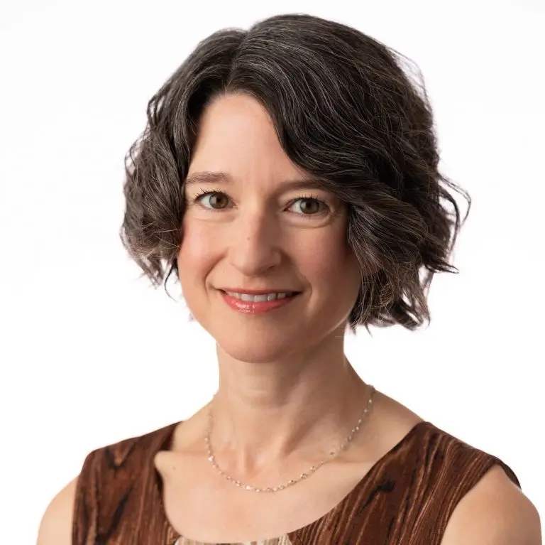 Brunette woman with short hair smiling at the camera.