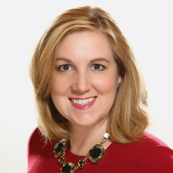 Smiling woman with shoulder length blonde hair and a red suit